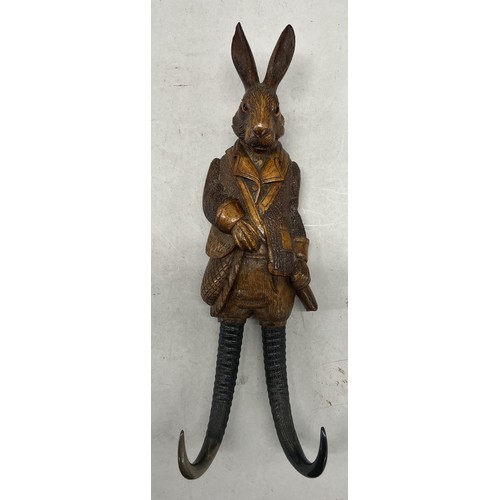 515 - A Black Forest style carved wooden musical hanging coat hook in the of a hare with glass eyes and ho... 