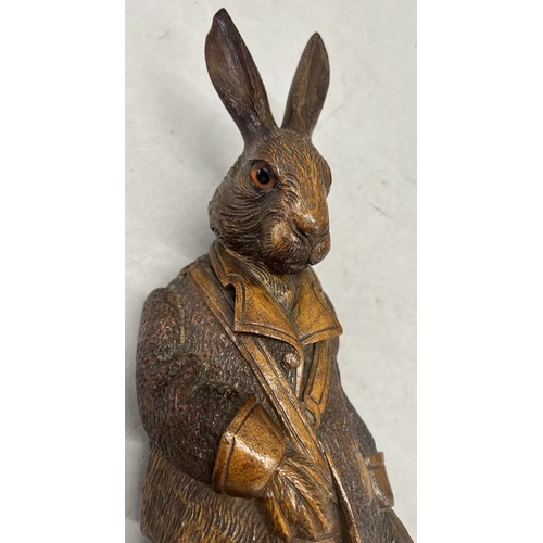 515 - A Black Forest style carved wooden musical hanging coat hook in the of a hare with glass eyes and ho... 