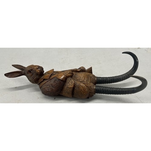 515 - A Black Forest style carved wooden musical hanging coat hook in the of a hare with glass eyes and ho... 