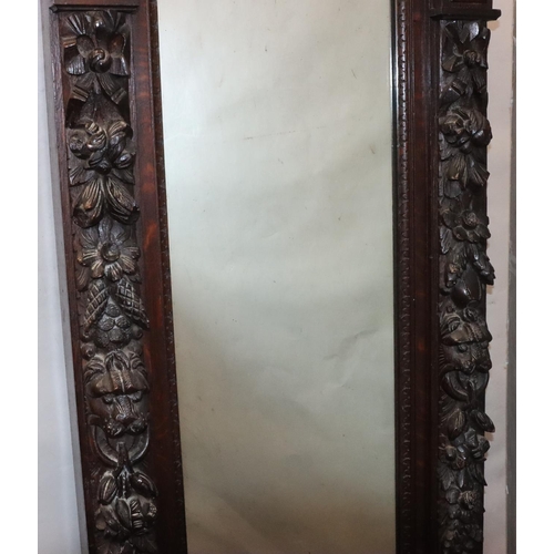 565 - A Victorian carved oak hall mirror with allover raised figurehead, fruit, leaf, scroll and thumb pat... 