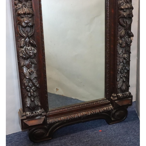 565 - A Victorian carved oak hall mirror with allover raised figurehead, fruit, leaf, scroll and thumb pat... 