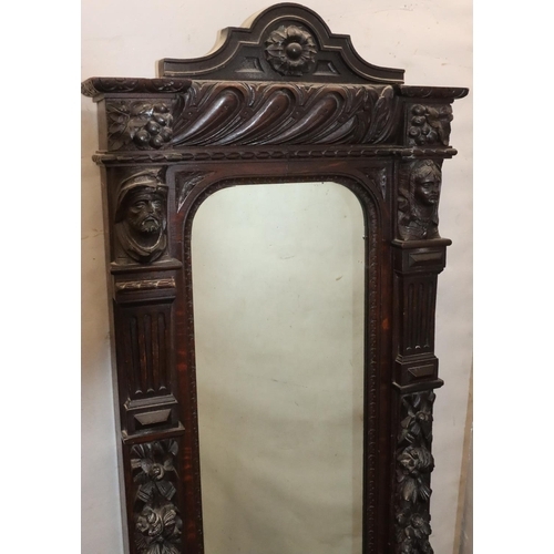 565 - A Victorian carved oak hall mirror with allover raised figurehead, fruit, leaf, scroll and thumb pat... 