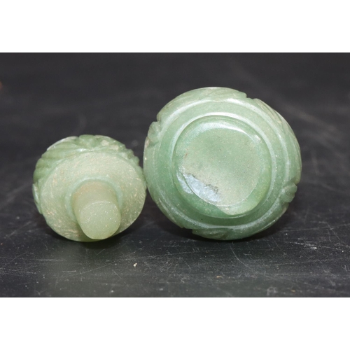 513 - An Oriental jade small round bulbous thin necked scent bottle with stopper and allover carved floral... 