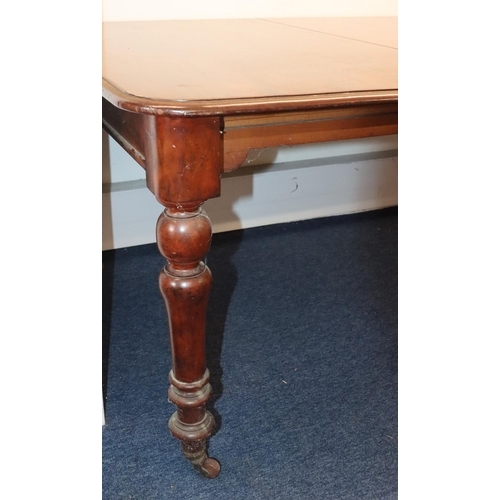 557 - A 19th Century mahogany draw leaf dining table with 1 extra leaf on round turned legs with brass toe... 