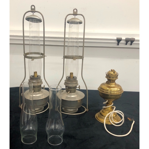 1008 - A pair of metallic hanging paraffin lamps converted to electricity, 64cm overall and another brass p... 