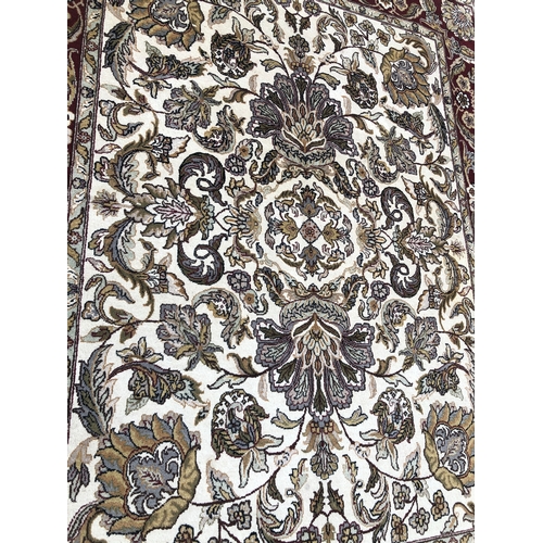 1018 - A modern hand knotted Indian rug on red and cream ground, 241 x 310cm.