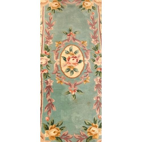 1020 - A wool rug on green and cream ground, 67 x 156cm (some staining)