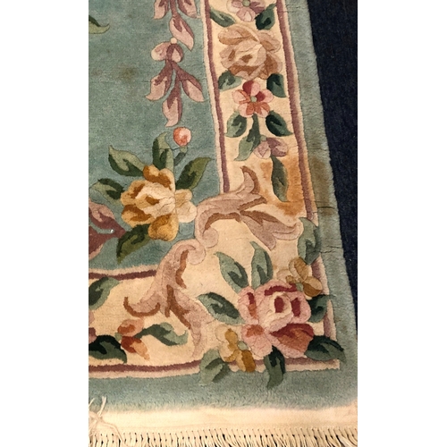 1020 - A wool rug on green and cream ground, 67 x 156cm (some staining)