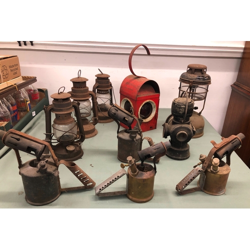 1035 - A vintage red Greenham road safety lamp and a quantity of various other lamps and blow torches.