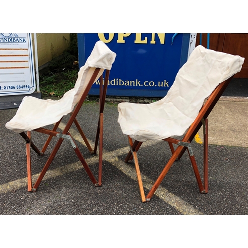 1130 - A pair of wooden framed folding chairs with canvas seat and matching canvas covers.