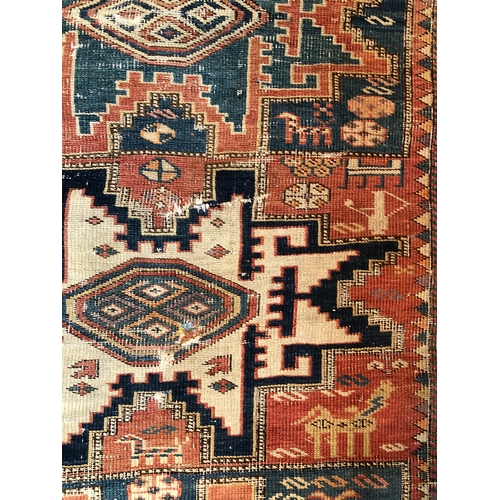 1164 - A woven rug, 183cm long, 113cm wide (generally worn, tassels and 1 corner worn away, repaired tear t... 