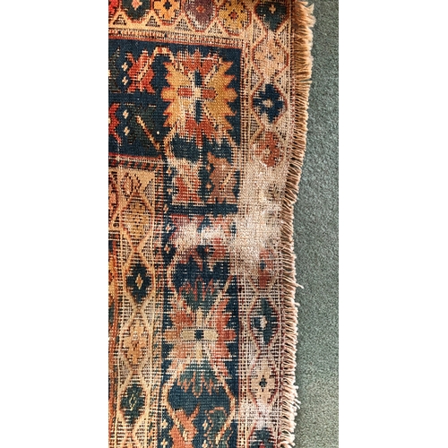 1164 - A woven rug, 183cm long, 113cm wide (generally worn, tassels and 1 corner worn away, repaired tear t... 