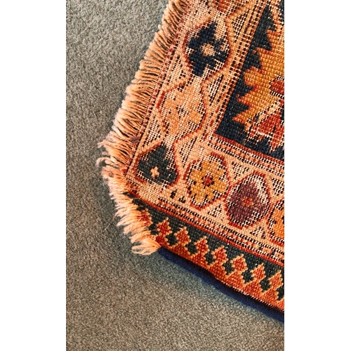 1164 - A woven rug, 183cm long, 113cm wide (generally worn, tassels and 1 corner worn away, repaired tear t... 