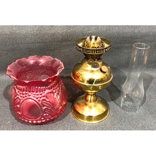 1202 - A gilt metal paraffin lamp with pink glass shade, 49cm high overall.