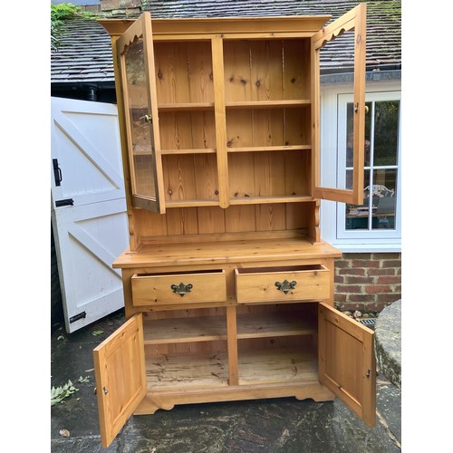 1258 - A pine dresser with 2 upper glazed doors enclosing shelves, 2 drawers and 2 lower cupboard doors, ba... 