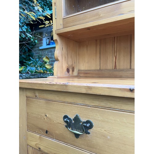 1258 - A pine dresser with 2 upper glazed doors enclosing shelves, 2 drawers and 2 lower cupboard doors, ba... 