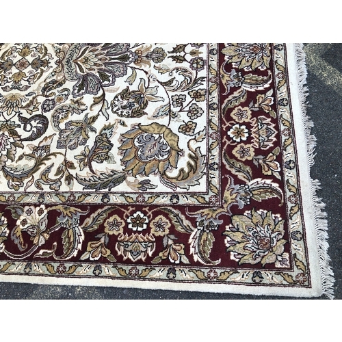 1018 - A modern hand knotted Indian rug on red and cream ground, 241 x 310cm.