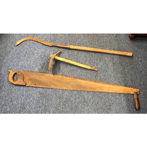 1038 - A large vintage 2-handled saw, 120cm long, a scythe and a pickaxe.