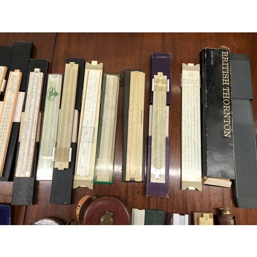 1351 - A quantity of various slide rules, 2 vintage measuring tapes, a protractor set etc.