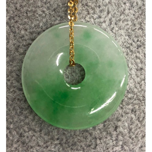 1265 - A jade circular pendant 2.6cm diameter with chain, 9cm long