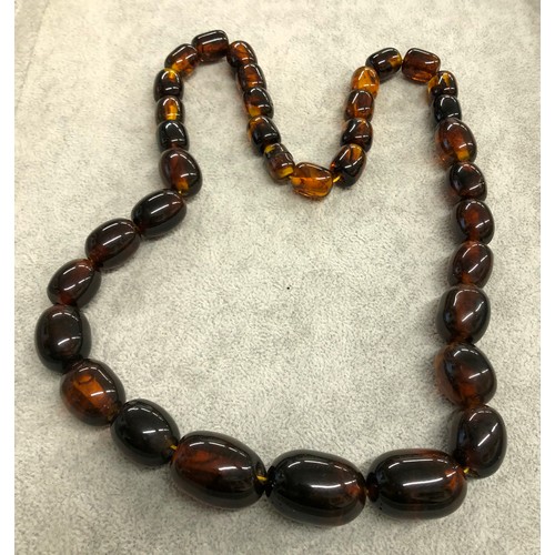 1294 - An amber style necklace, 64cm long.