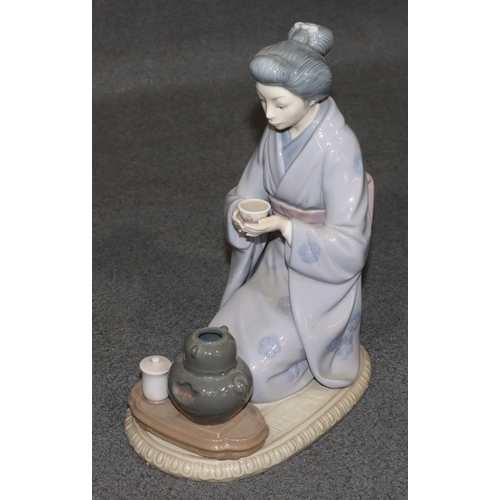 164 - A Lladro figure of a kneeling Oriental lady holding a cup, 22cm high