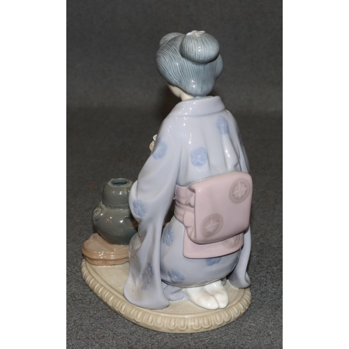 164 - A Lladro figure of a kneeling Oriental lady holding a cup, 22cm high