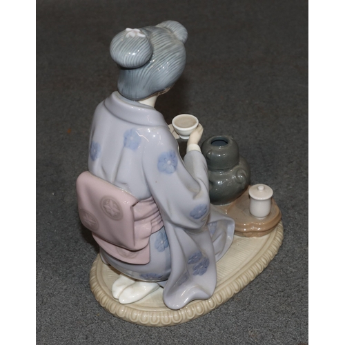 164 - A Lladro figure of a kneeling Oriental lady holding a cup, 22cm high