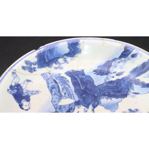 172 - An early Chinese blue and white plate depicting figures and servant in rocky landscape, 21cm diamete... 