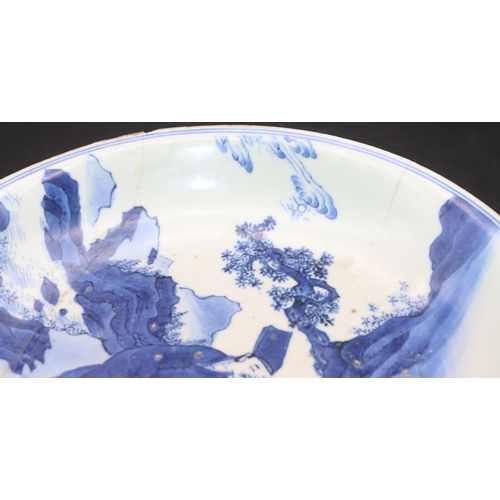 172 - An early Chinese blue and white plate depicting figures and servant in rocky landscape, 21cm diamete... 