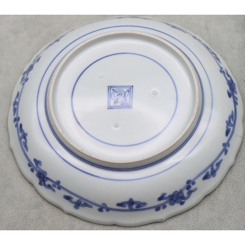 173 - An Oriental blue and white small round scallop shaped dish with multi-coloured perched bird, fruit a... 