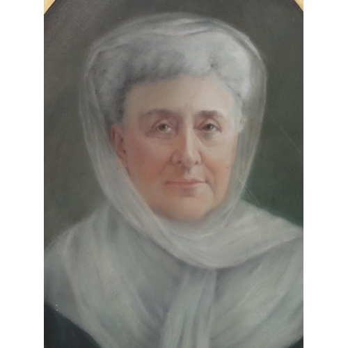 193 - An oval pastel, 54.5cm x 39.5cm, shoulder length portrait of an elderly lady wrapped in white scarf,... 