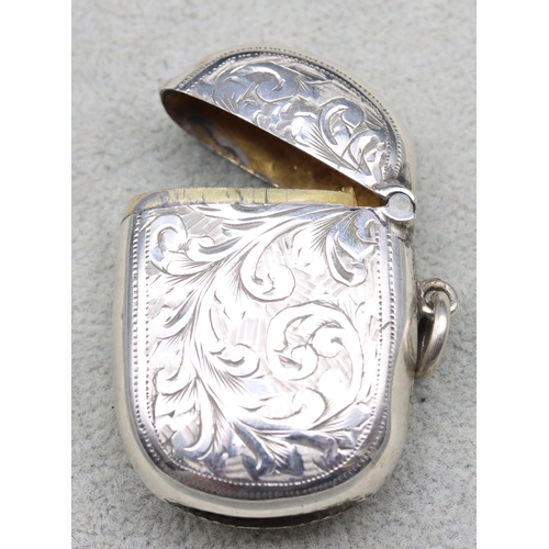 300 - A Birmingham silver vesta case with hinged lid and allover leaf and scroll decoration, 4.5cm high