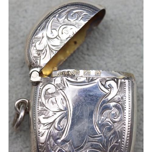 300 - A Birmingham silver vesta case with hinged lid and allover leaf and scroll decoration, 4.5cm high