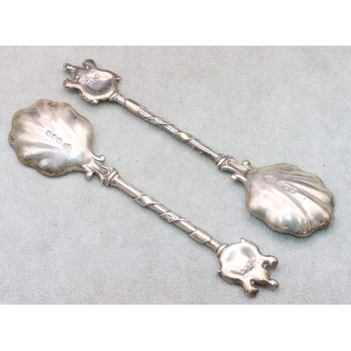 309 - A pair of Edward VII heavy silver spoons with shell shaped bowls with crest finials, in fitted Carri... 