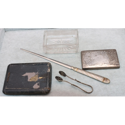 314 - A cut glass rectangular shaped dressing table pot with silver lid, a pair of Continental silver tong... 