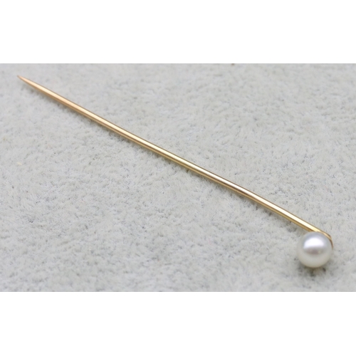 523 - A gold stick pin with pearl motif, 1.1 grams gross (cased)