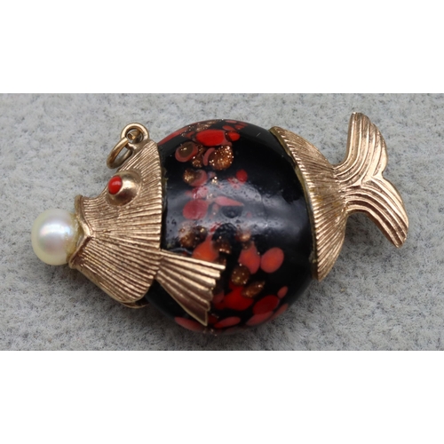 526 - A 9ct gold and glass charm in the form of a fish holding a pearl in its mouth, 4cm long, 9.6 grams g... 