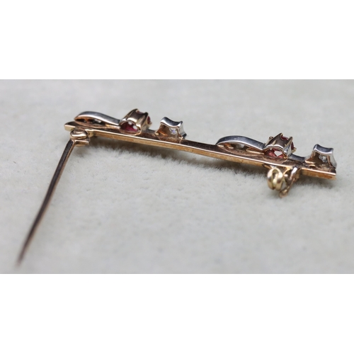 541 - A gold bar brooch mounted with 2 red stones surrounded by 8 small diamonds (1 diamond missing), 4.5c... 