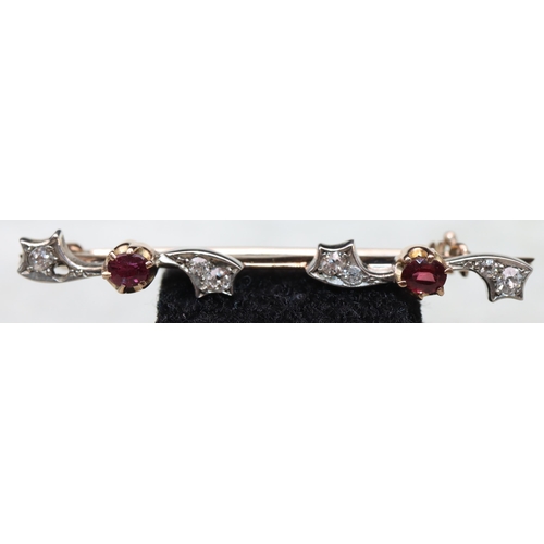 541 - A gold bar brooch mounted with 2 red stones surrounded by 8 small diamonds (1 diamond missing), 4.5c... 