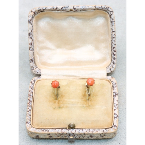 557 - A pair of 9ct gold coral earrings with screw backs, 0.9 grams gross (boxed)