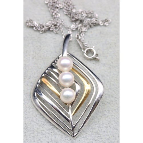 574 - An 18ct gold and silver cultured pearl pendant in the form of a leaf, with silver chain, 5cm high wi... 