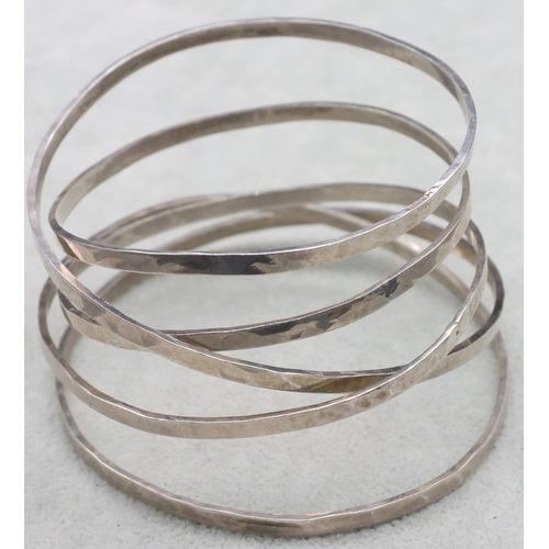 585 - A silver hammered 5-ring handmade bangle, 56.9 grams