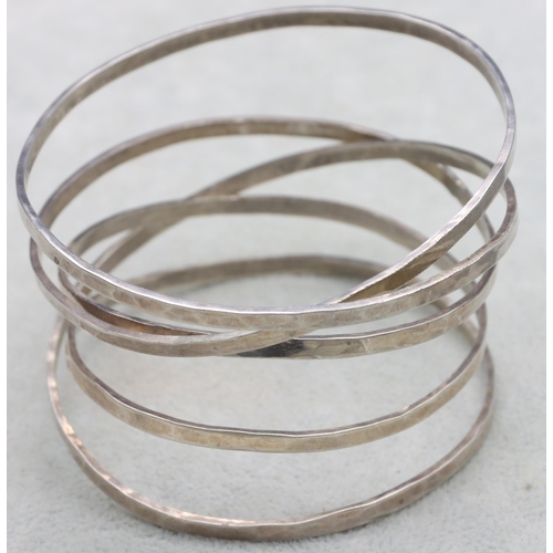 585 - A silver hammered 5-ring handmade bangle, 56.9 grams