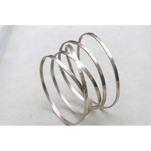 585 - A silver hammered 5-ring handmade bangle, 56.9 grams