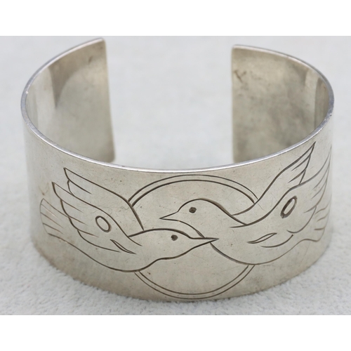 587 - A large silver white band bangle with engraved dove motifs, 94.2 grams