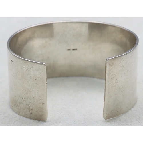 587 - A large silver white band bangle with engraved dove motifs, 94.2 grams