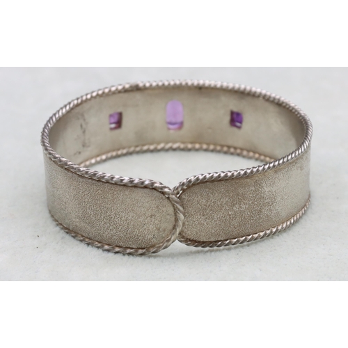 588 - A silver and amethyst mounted bangle, 37.2 grams gross