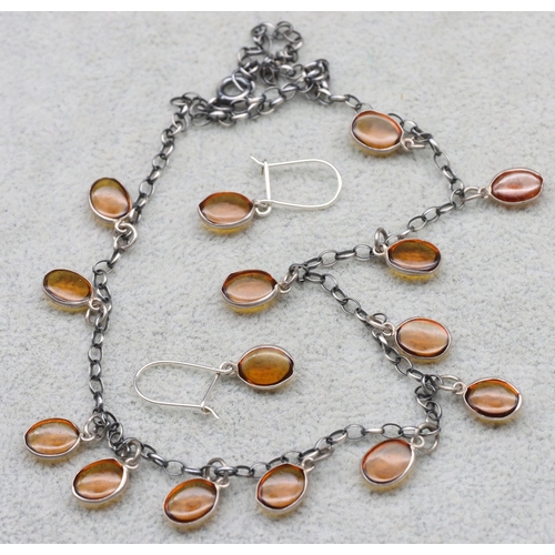 591 - A silver necklace mounted with various amber drops and a pair of similar earrings (3)