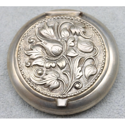 595 - An 800 silver coloured metal circular compact with embossed hinged lid, 40.1 grams gross